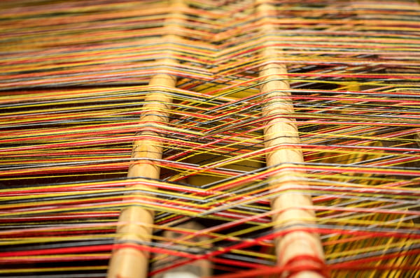 close-up-of-brocade-fabric-weaving-on-loom-cotton-on-the-manual-wood-loom-traditional-axminster-carpet