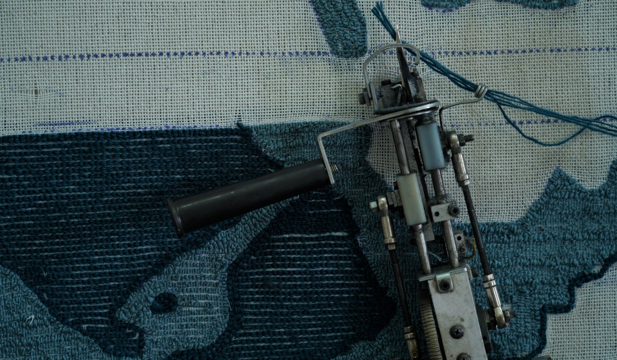 Tufting gun on blue rug sample