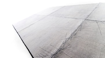 grauer Teppich aus einfarbigen Patchwork Quadraten zusammengenäht minimalistisch und robust