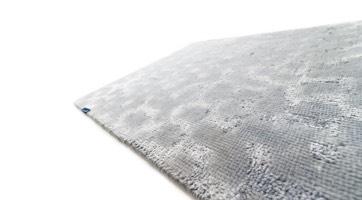 hellgrauer Teppich aus matter Wolle und glänzender Viskose mit abstraktem Design verschwimmende Punkte